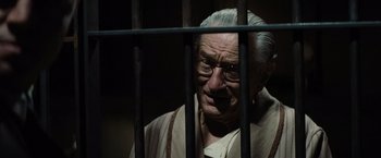Movie still from “Killers of the Flower Moon” (2023), directed by Martin Scorsese – An old man with glasses behind bars in a jail cell; Close Up shot, Low angle