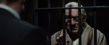 Movie still from “Killers of the Flower Moon” (2023), directed by Martin Scorsese – An old man with glasses is behind bars; Close Up shot, Over the shoulder angle