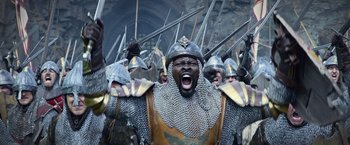 Movie still from “King Arthur: Legend of the Sword” (2017), directed by Guy Ritchie – A group of men in medieval armor and helmets; Medium shot, High angle