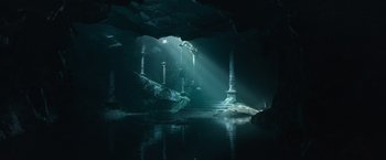 Movie still from “King Arthur: Legend of the Sword” (2017), directed by Guy Ritchie – A dark cave filled with lots of water and sunlight; Extreme Wide shot, High angle