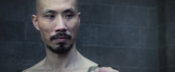 Movie still from “King Arthur: Legend of the Sword” (2017), directed by Guy Ritchie – A man with a shaved head and a beard; Close Up shot, Over the shoulder angle