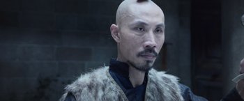 Movie still from “King Arthur: Legend of the Sword” (2017), directed by Guy Ritchie – A man with a shaved head and a bald head; Close Up shot, Over the shoulder angle