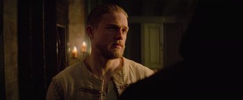 Movie still from “King Arthur: Legend of the Sword” (2017), directed by Guy Ritchie – A person in a room with candles; Close Up shot, Over the shoulder angle