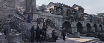 Movie still from “King Arthur: Legend of the Sword” (2017), directed by Guy Ritchie – A group of people standing on some steps; Wide shot, High angle