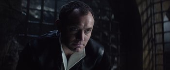 Movie still from “King Arthur: Legend of the Sword” (2017), directed by Guy Ritchie – A person wearing a suit and tie; Close Up shot, Over the shoulder angle
