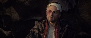 Movie still from “King Arthur: Legend of the Sword” (2017), directed by Guy Ritchie – A man with bandages on his head and a bandage on his face; Close Up shot, Over the shoulder angle