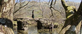 Movie still from “King Arthur: Legend of the Sword” (2017), directed by Guy Ritchie – A man standing on top of a bridge near a woman; Extreme Wide shot, High angle