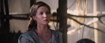 Movie still from “King Arthur: Legend of the Sword” (2017), directed by Guy Ritchie – A woman in a dress looking to her left; Close Up shot, Over the shoulder angle