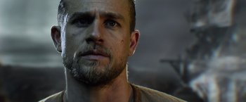 Movie still from “King Arthur: Legend of the Sword” (2017), directed by Guy Ritchie – A person with a beard; Close Up shot, Low angle