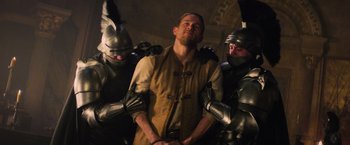 Movie still from “King Arthur: Legend of the Sword” (2017), directed by Guy Ritchie – A group of men standing next to each other in armor; Medium shot, Over the shoulder angle