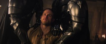 Movie still from “King Arthur: Legend of the Sword” (2017), directed by Guy Ritchie – A person wearing a suit of armor; Close Up shot, Over the shoulder angle