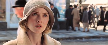 Movie still from “King Kong” (2005), directed by Peter Jackson – A person wearing a hat with people in the background; Close Up shot, Over the shoulder angle