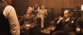 Movie still from “King Kong” (2005), directed by Peter Jackson – A group of men in suits sitting in a room; Medium shot, High angle
