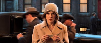 Movie still from “King Kong” (2005), directed by Peter Jackson – A woman holding a cell phone while standing in front of a crowd; Close Up shot, Over the shoulder angle