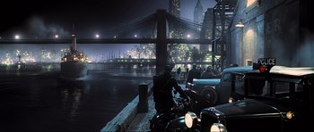 Movie still from “King Kong” (2005), directed by Peter Jackson – A man sitting on the side of a river next to a motorcycle; Extreme Wide shot, High angle