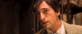 Movie still from “King Kong” (2005), directed by Peter Jackson – A person wearing a suit and tie; Close Up shot, High angle