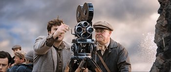 Movie still from “King Kong” (2005), directed by Peter Jackson – Two men standing next to each other with a movie camera; Medium shot, Low angle