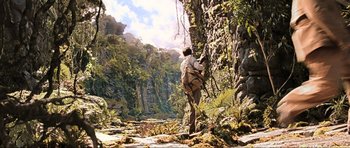 Movie still from “King Kong” (2005), directed by Peter Jackson – A man standing next to a tree in the middle of a forest; Extreme Wide shot, Low angle