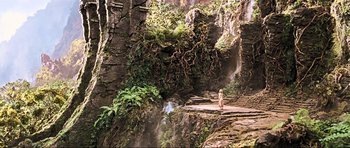 Movie still from “King Kong” (2005), directed by Peter Jackson – A person standing in front of a waterfall in the woods; Extreme Wide shot, High angle