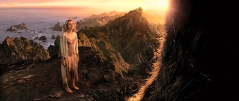 Movie still from “King Kong” (2005), directed by Peter Jackson – A woman standing on top of a hill next to an animal; Wide shot, Low angle