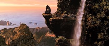 Movie still from “King Kong” (2005), directed by Peter Jackson – A man sitting on a cliff looking out over the ocean; Extreme Wide shot, High angle