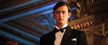 Movie still from “King Kong” (2005), directed by Peter Jackson – A man in a suit and bow tie wearing glasses; Close Up shot, Low angle