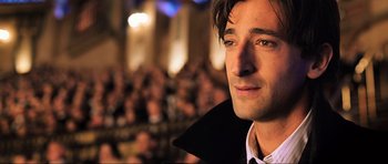 Movie still from “King Kong” (2005), directed by Peter Jackson – A man's face in front of an audience; Close Up shot, Over the shoulder angle