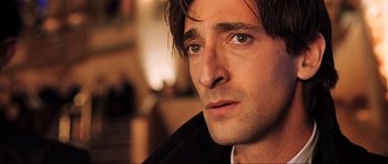 Movie still from “King Kong” (2005), directed by Peter Jackson – A man's face in a black jacket; Close Up shot, Over the shoulder angle