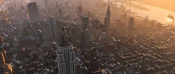 Movie still from “King Kong” (2005), directed by Peter Jackson – An aerial view of a large city at sunset; Extreme Wide shot, High angle