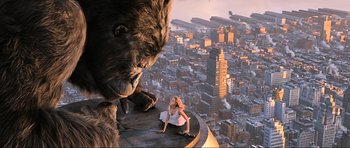 Movie still from “King Kong” (2005), directed by Peter Jackson – A woman sitting on top of a building next to a large gorilla; Wide shot, Low angle