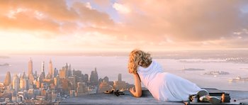 Movie still from “King Kong” (2005), directed by Peter Jackson – A woman laying on a ledge looking at the city; Wide shot, Overhead angle