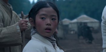 Movie still from “Kingdom: Ashin of the North” (2021), directed by Kim Seong-hun – A young asian girl with long black hair and blue eyes; Close Up shot, Over the shoulder angle