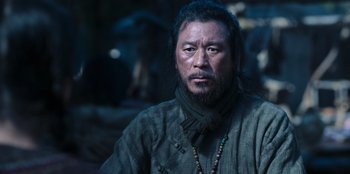 Movie still from “Kingdom: Ashin of the North” (2021), directed by Kim Seong-hun – A man with long black hair and a beard; Close Up shot, Low angle