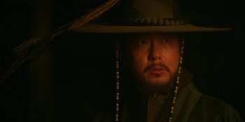 Movie still from “Kingdom: Ashin of the North” (2021), directed by Kim Seong-hun – A man wearing a hat and a beard; Close Up shot, Low angle