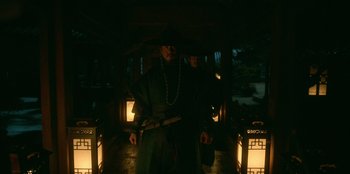 Movie still from “Kingdom: Ashin of the North” (2021), directed by Kim Seong-hun – A man standing in the dark holding a sword; Medium shot, Low angle