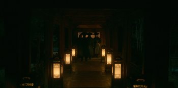 Movie still from “Kingdom: Ashin of the North” (2021), directed by Kim Seong-hun – A group of people standing in a hallway with lights; Wide shot, High angle