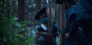 Movie still from “Kingdom: Ashin of the North” (2021), directed by Kim Seong-hun – Two people in a forest with a hat on; Medium shot, Over the shoulder angle