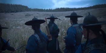 Movie still from “Kingdom: Ashin of the North” (2021), directed by Kim Seong-hun – A group of men in traditional japanese clothing and hats; Wide shot, Low angle