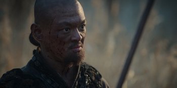 Movie still from “Kingdom: Ashin of the North” (2021), directed by Kim Seong-hun – A person holding a sword and looking at the camera; Close Up shot, Low angle