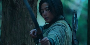 Movie still from “Kingdom: Ashin of the North” (2021), directed by Kim Seong-hun – A person holding a sword in a forest; Close Up shot, Low angle