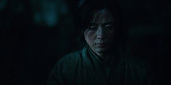 Movie still from “Kingdom: Ashin of the North” (2021), directed by Kim Seong-hun – A woman in a green shirt is looking at the camera; Close Up shot, Low angle