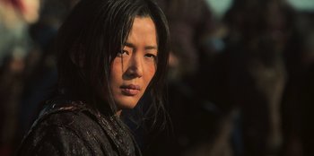 Movie still from “Kingdom: Ashin of the North” (2021), directed by Kim Seong-hun – A woman with long black hair is looking at the camera; Close Up shot, Low angle