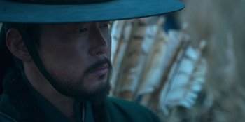 Movie still from “Kingdom: Ashin of the North” (2021), directed by Kim Seong-hun – A person wearing a hat; Close Up shot, Low angle