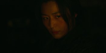 Movie still from “Kingdom: Ashin of the North” (2021), directed by Kim Seong-hun – A woman with long hair is looking at the camera; Close Up shot, Over the shoulder angle