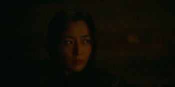 Movie still from “Kingdom: Ashin of the North” (2021), directed by Kim Seong-hun – A young woman is looking into the dark; Close Up shot, Over the shoulder angle
