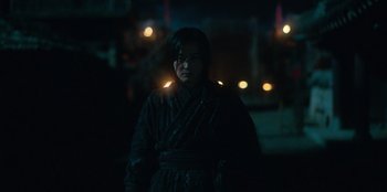 Movie still from “Kingdom: Ashin of the North” (2021), directed by Kim Seong-hun – A man in a black robe standing in the dark; Medium shot, Low angle