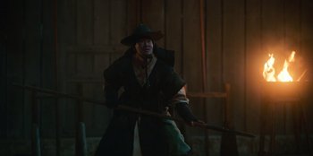 Movie still from “Kingdom: Ashin of the North” (2021), directed by Kim Seong-hun – A man dressed as a witch holding a broom; Medium shot, Low angle