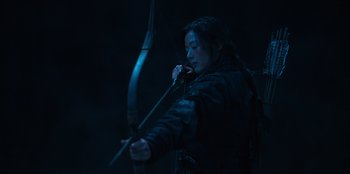 Movie still from “Kingdom: Ashin of the North” (2021), directed by Kim Seong-hun – A man holding a bow and arrow in a dark room; Medium shot, Low angle