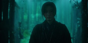 Movie still from “Kingdom: Ashin of the North” (2021), directed by Kim Seong-hun – A person standing in the middle of a forest; Medium shot, Low angle