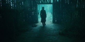 Movie still from “Kingdom: Ashin of the North” (2021), directed by Kim Seong-hun – A man walking down a path in the dark; Wide shot, Low angle